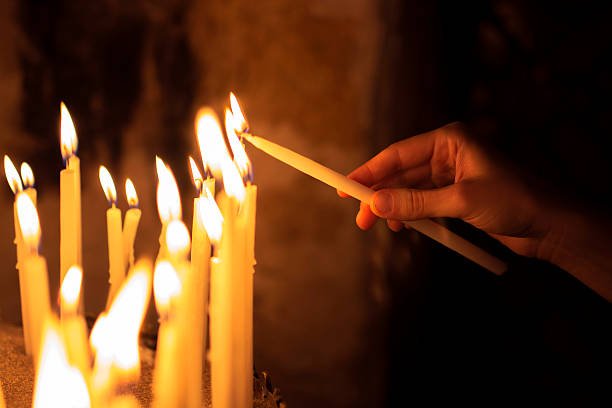 woman lighting candles in a church